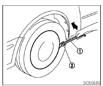 Removing the wheel cover safely using a jacking rod on a Nissan Versa