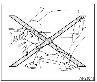 Warning illustration demonstrating a passenger sitting sideways and resting their legs on the dashboard of a Nissan Versa