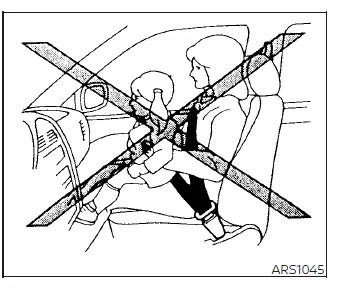 Warning diagram showing a child riding in the front passenger seat of a Nissan Versa with the seat belt improperly routed under their arm